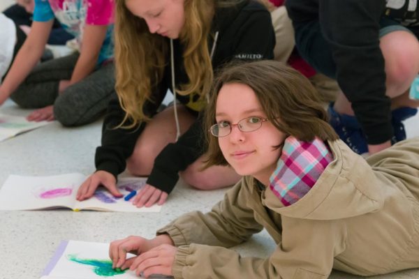A girl drawing with pastels.