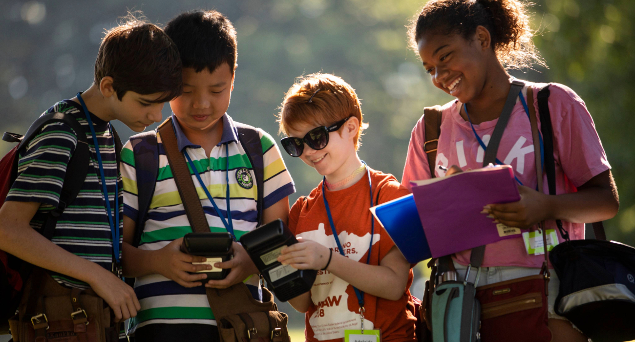 kids gathered near looking at maps